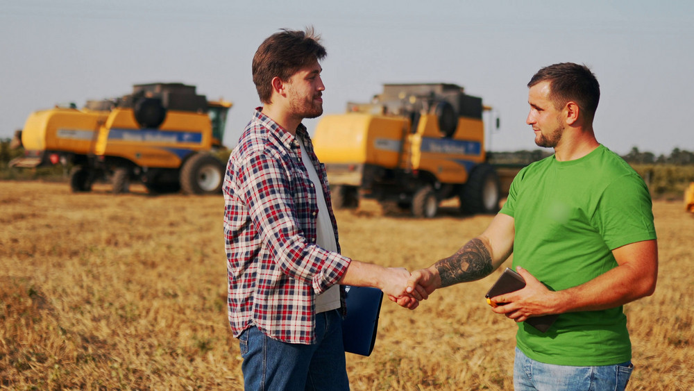 An Alloway dealer and a grower shaking hands in the field